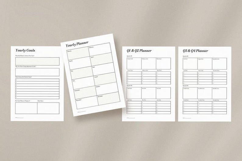 May include: Four white paper planner sheets with black text are arranged on a neutral background. The sheets include "Yearly Goals", "Yearly Planner", "Q1 & Q2 Planner", and "Q3 & Q4 Planner". The "Yearly Planner" sheet has a calendar layout.