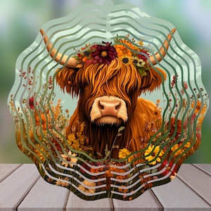 Puede incluir: Una vaca Highland marrón y blanca con pelo largo y peludo, que lleva una corona de flores. La vaca está rodeada de un patrón de flores y hojas en espiral, creando un diseño caprichoso y colorido.