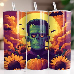 May include: A Halloween-themed tumbler with a green Frankenstein's monster design, a pumpkin, sunflowers, bats, and a full moon. The tumbler has a straw and is decorated with orange, purple, and yellow colours.