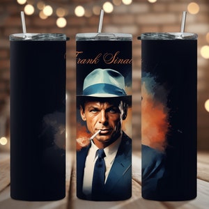 May include: A black stainless steel tumbler with a colorful image of Frank Sinatra. The image features a watercolor-style background with a portrait of Sinatra wearing a blue hat and suit.