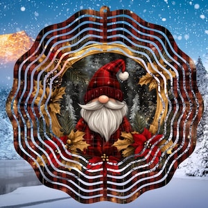 Puede incluir: Un molinillo de viento de cuadros rojos y blancos con un diseño circular. El centro del molinillo presenta un gnomo con un gorro rojo y barba blanca, rodeado de una corona de hojas verdes y poinsettias rojas.