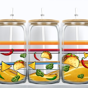 May include: Three clear glass jars with wooden lids and straws. Each jar has a colorful striped design and is filled with a yellow liquid. The jars are decorated with images of tacos, peppers, and tortilla chips.