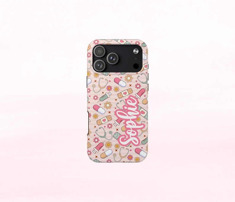 May include: A phone case with a light pink background featuring a pattern of medical-themed illustrations, including pills, bandages, stethoscopes, and syringes. The name "Sophie" is written in a cursive font.