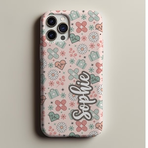May include: A pink phone case with a repeating pattern of medical symbols, including bandages, hearts, and first aid kits. The name "Sophie" is written in a cursive font on the case.