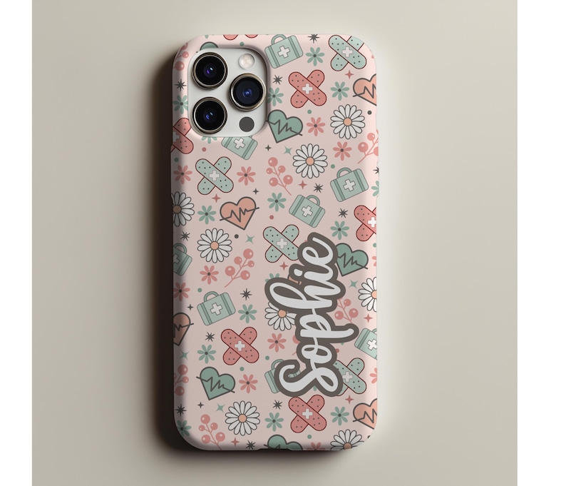 May include: A pink phone case with a repeating pattern of medical symbols, including bandages, hearts, and first aid kits. The name "Sophie" is written in a cursive font on the case.
