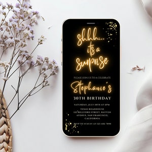 May include: A black smartphone screen with a gold glitter background and text that reads "shhh... it's a surprise" in a neon yellow font. The text "Please join us to celebrate Stephanie's 30th Birthday" is also on the screen in a white font. The text below includes the date, time, location, and RSVP information.