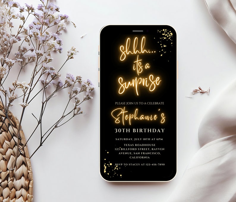 May include: A black smartphone screen with a gold glitter background and text that reads "shhh... it's a surprise" in a neon yellow font. The text "Please join us to celebrate Stephanie's 30th Birthday" is also on the screen in a white font. The text below includes the date, time, location, and RSVP information.