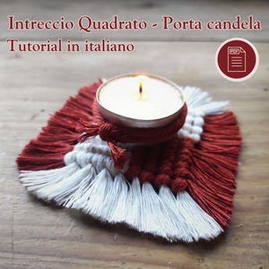 Può includere: Una candela accesa in un portacandele argentato è posizionata su un sottobicchiere quadrato in macramè. Il sottobicchiere presenta un design a frange rosse e bianche. Il testo in italiano recita "Intreccio Quadrato - Porta candela Tutorial in italiano".