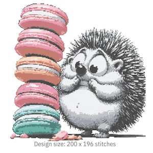 Op de afbeelding: Kruissteekontwerp met een cartoonegel die naar een stapel kleurrijke macarons kijkt. De macarons zijn roze, oranje en blauwgroen. De egel heeft een verraste uitdrukking. Ontwerpformaat: 200 x 196 steken.