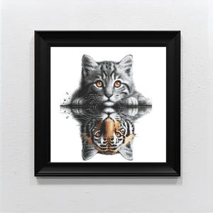 Op de afbeelding: Een ingelijste print met een grijze tabbykat met oranje ogen, weerspiegeld in het water als een tijger. Het kunstwerk staat in een zwarte lijst tegen een witte achtergrond. De reflectie van de kat toont een tijger.