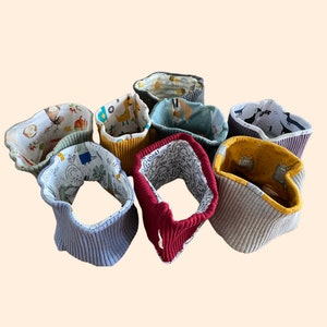 Peut inclure: Un ensemble de huit chauffe-cou en tissu coloré avec différents motifs, notamment des animaux, des formes géométriques et des motifs abstraits. Les chauffe-cou sont faits d'un matériau doux et tricoté et sont parfaits pour se tenir au chaud en hiver.