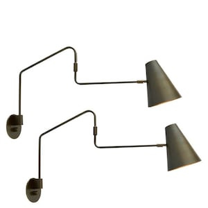 May include: Two black metal wall sconces with adjustable arms and cone-shaped shades. The shades are angled downwards.