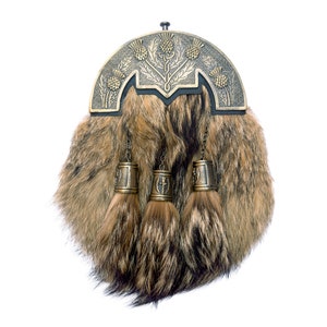 May include: A brown fur sporran with a decorative metal top featuring a thistle design. The sporran has three tassels with metal bells.
