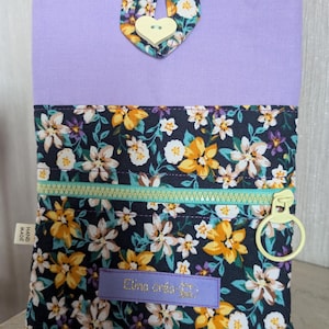 Op de afbeelding: Een paarse en zwarte stoffen etui met rits en bloemenprint. De etui heeft een hartvormige knoop en een rits met een ring. De etui is gelabeld met "Elina crea".