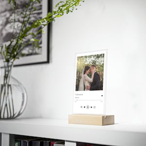 Customizable acrylic glass including a wooden display with picture, title and date