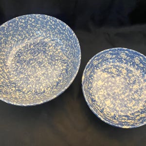 May include: A set of three ceramic mugs with a speckled, matte finish. The mugs are in shades of cream, light gray, and dark gray. Each mug has a simple, minimalist design, perfect for coffee or tea.