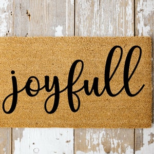 May include: A brown coir doormat with the word "joyfull" written in black cursive script.