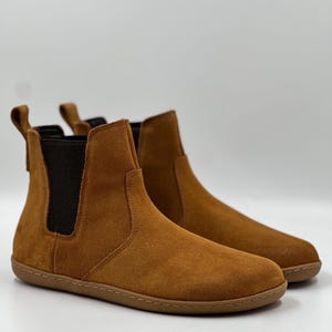 Chelseaboot van suède op blote voeten