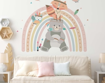 May include: A colorful rainbow wall decal with a bear, fox, and owl wearing headdresses. The rainbow is made up of pink, yellow, blue, and green stripes. There are also small triangles and feathers scattered around the rainbow.