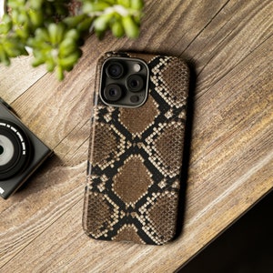 May include: A brown and black snake skin patterned phone case for an iPhone.