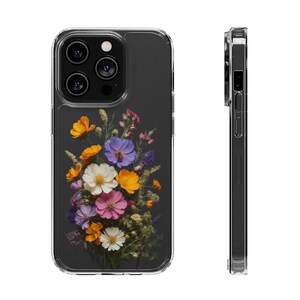 May include: A clear phone case with a floral design. The case features a bouquet of pressed flowers in shades of purple, pink, yellow, and white. The flowers are arranged in a cluster on a dark gray background.