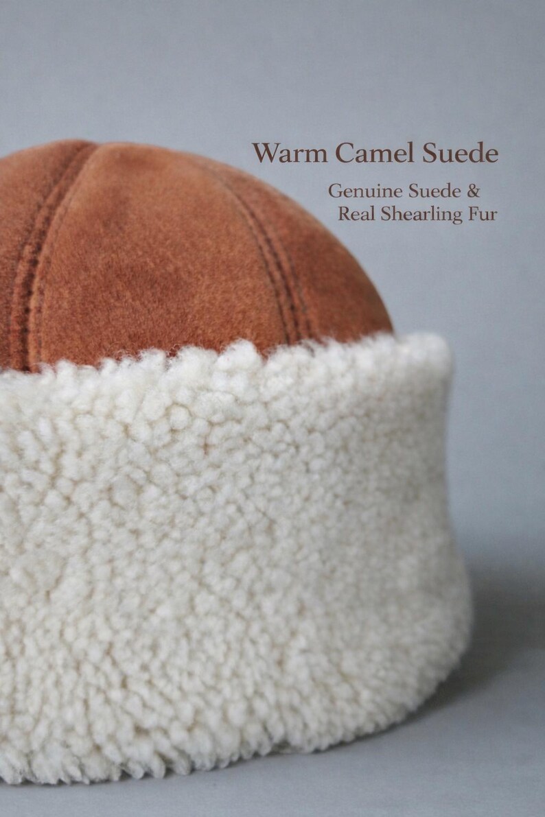May include: A warm camel suede hat with a genuine suede crown and a real shearling fur brim. The hat is a light brown color with a white fur brim. The text "Warm Camel Suede" and "Genuine Suede & Real Shearling Fur" is visible.