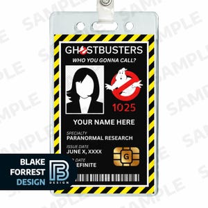 May include: A Ghostbusters ID badge in a clear plastic holder. The badge displays the Ghostbusters logo, the text "WHO YOU GONNA CALL?", and a space for a name. It includes a photo, the number 1025, and the specialty "PARANORMAL RESEARCH".