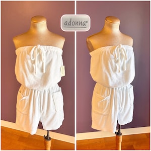 May include: A white strapless terry cloth playsuit featuring a drawstring neckline, an elasticated waist, and two front patch pockets. The garment includes a tag with the brand name adonna. The playsuit is displayed on a mannequin torso.