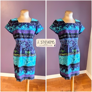 May include: A vintage dress with a square neckline and short sleeves. The dress features a floral pattern in shades of blue, purple, and green. The dress is displayed on a mannequin. The text "J. Stevens" is visible.