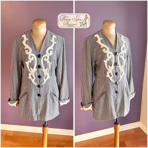 Puede incluir: Blazer a cuadros blancos y negros con detalles bordados blancos y botones negros. El blazer tiene mangas largas con ribete de encaje blanco en los puños y bolsillos. La etiqueta dice "Helen Sykes Fashions Leeds".