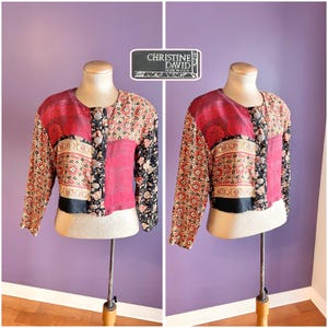 Pode incluir: Casaco vintage em patchwork com decote redondo e mangas compridas. O casaco apresenta uma mistura de painéis de tecido floral, geométrico e liso em vermelho, preto e bege. A etiqueta diz "CHRISTINE DAVID MADE IN U.S.A."