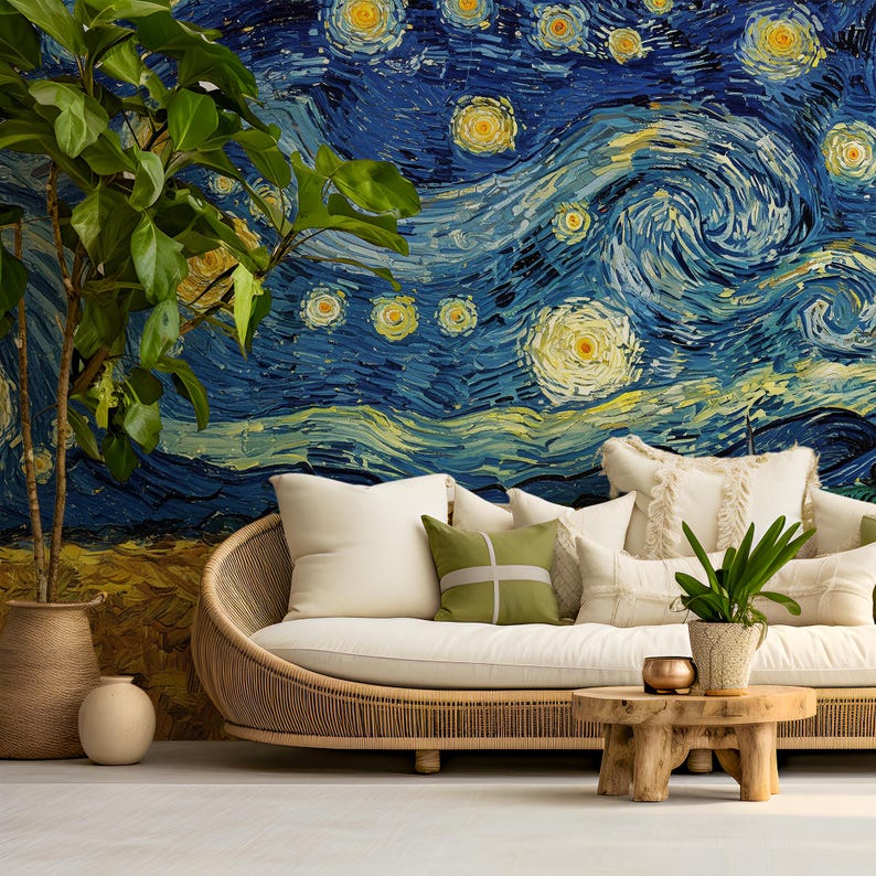 May include: A curved rattan sofa with cream cushions and decorative pillows, including a green square pillow with a white cross. A small wooden coffee table holds a potted plant, while a large potted plant stands beside the sofa against a mural.