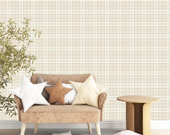 May include: A cozy living room scene featuring a beige plaid wallpaper backdrop. A light brown armchair with star-shaped pillows in white, brown, and cream sits on a gray rug. A small wooden side table and decorative plant complete the scene.