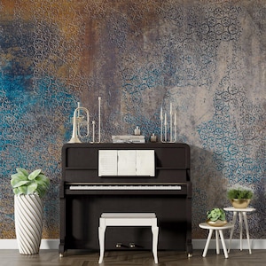 May include: A black upright piano with a white bench in front of it. The piano is in front of a wall with a blue and brown patterned wallpaper. There are two small plants on the floor to the right of the piano.
