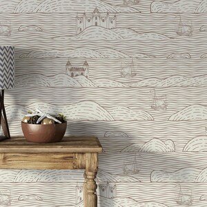 May include: A wooden table with a brown bowl containing a white starfish, set against wallpaper featuring a repeating pattern of brown line-drawn castles, sailing ships, and rolling hills on a cream-colored background with horizontal wavy lines.