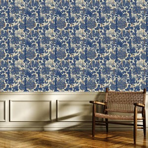 May include: Wallpaper featuring a dense, repeating botanical pattern in deep blue on a cream background, depicting various palm trees, cacti, and tropical foliage. The design covers the wall above white wainscoting and a wooden floor.