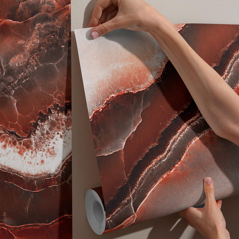 May include: A roll of wallpaper featuring a deep red and dark brown agate stone pattern with white veining. The design mimics the layered, organic texture of natural rock formations, displaying a smooth, matte finish across the surface of the paper.
