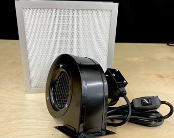 May include: A black fan with a metal grill and a white filter in a silver frame. The fan has a power cord and an on/off switch.