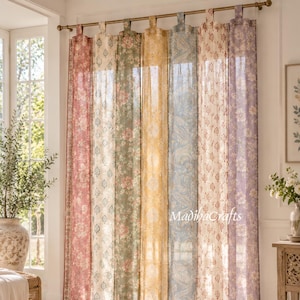 Peut inclure: Un ensemble de six rideaux à pattes pleine longueur suspendus à une tringle en métal. Chaque panneau présente un motif floral ou cachemire distinct dans des tons de rose, vert, jaune, bleu et violet, avec le texte MadihaCrafts sur le panneau bleu.