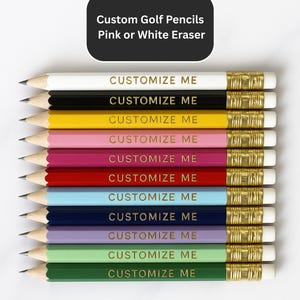 May include: A collection of ten golf pencils in various colors, including white, black, yellow, pink, red, blue, navy, purple, and green. Each pencil has a gold ferrule and a pink or white eraser. The text "CUSTOMIZE ME" is printed on each pencil.