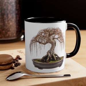 Puede incluir: Taza de cerámica blanca con borde y asa negros. La taza presenta una imagen impresa de un bonsái con ramas lloronas en una maceta marrón.