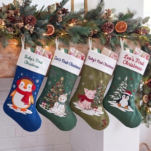 May include: Four Christmas stockings with white cuffs featuring embroidered text. The first is blue with a penguin, the second is green with a snowman and tree, the third is olive with a pig and tree, and the fourth is green with a penguin and tree.