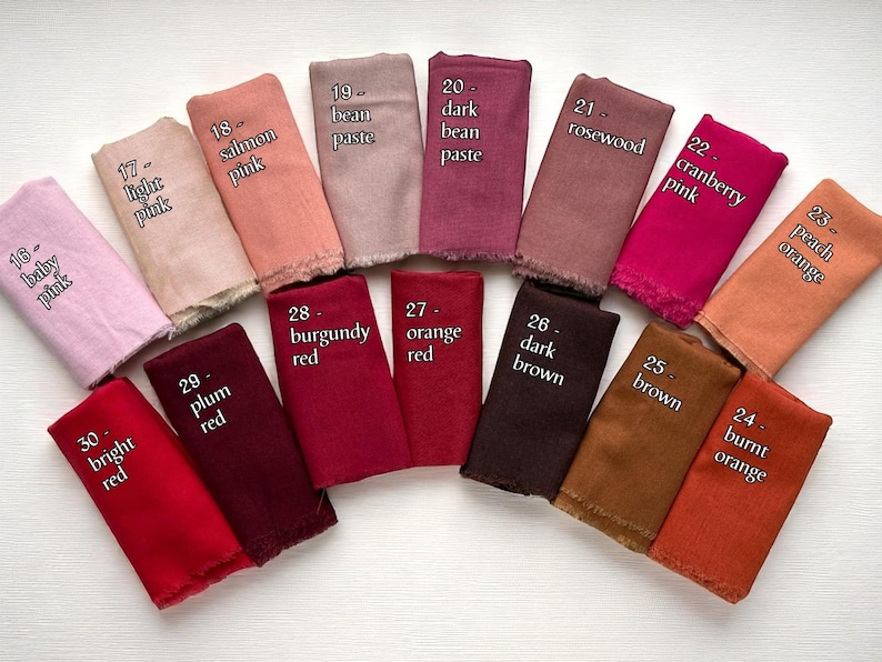 May include: A collection of fabric swatches in various colors, including baby pink, light pink, salmon pink, bean paste, dark bean paste, rosewood, cranberry pink, peach orange, burnt orange, brown, dark brown, orange red, burgundy red, plum red, and bright red. Each swatch has a label with its color name.