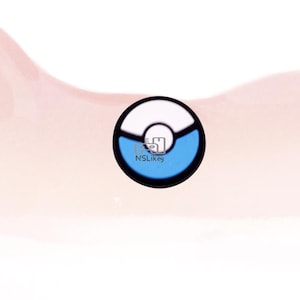 May include: A round, black, white, and blue design with the text "NSLIkey" in the center. The design is a circle with a white top half and a blue bottom half, separated by a black line.