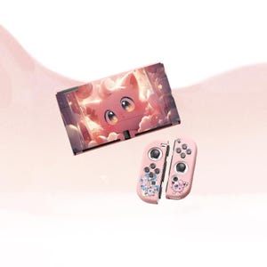 May include: Pink Nintendo Switch console and Joy-Con controllers. The console has a pink cat graphic with a cloudy background. The Joy-Cons are pink with cartoon character designs. The background is a soft pink gradient.