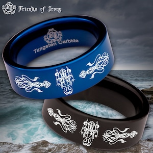 Könnte beinhalten: Zwei Ringe aus Wolframcarbid mit einem weißen Kraken-Design. Der Ring links ist blau und der Ring rechts ist schwarz. Die Ringe sind vor dem Hintergrund eines stürmischen Ozeans platziert.