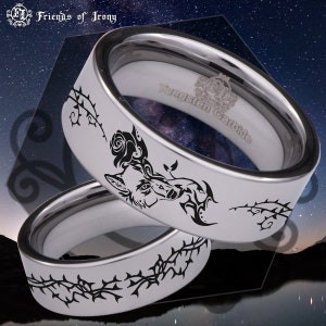 May include: Two silver tungsten carbide rings with black engravings. The top ring features a wolf's head with a rose and thorns. The bottom ring features a thorn vine design. The inside of the top ring is engraved with "Tungsten Carbide".