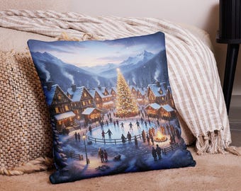 Könnte beinhalten: Ein dekoratives Kissen mit einer Winterdorf-Szene. Das Bild zeigt einen beleuchteten Weihnachtsbaum in der Mitte einer Eisbahn, umgeben von schneebedeckten Gebäuden und Bergen. Menschen fahren Schlittschuh und versammeln sich um ein Lagerfeuer.