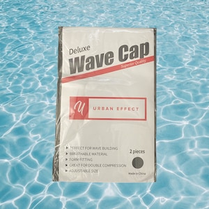 May include: A package for a black wave cap with the text "Deluxe Wave Cap Superior Quality" and "Urban Effect". The package lists features such as "Perfect for wave building", "Breathable material", "Form fitting", "Great for double compression", and "Adjustable size". The package also states "2 pieces" and "Made in China".