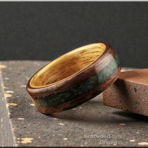 Bague en bois courbé incrusté d'émeraudes : noyer bouclé, noyau de limba noir
